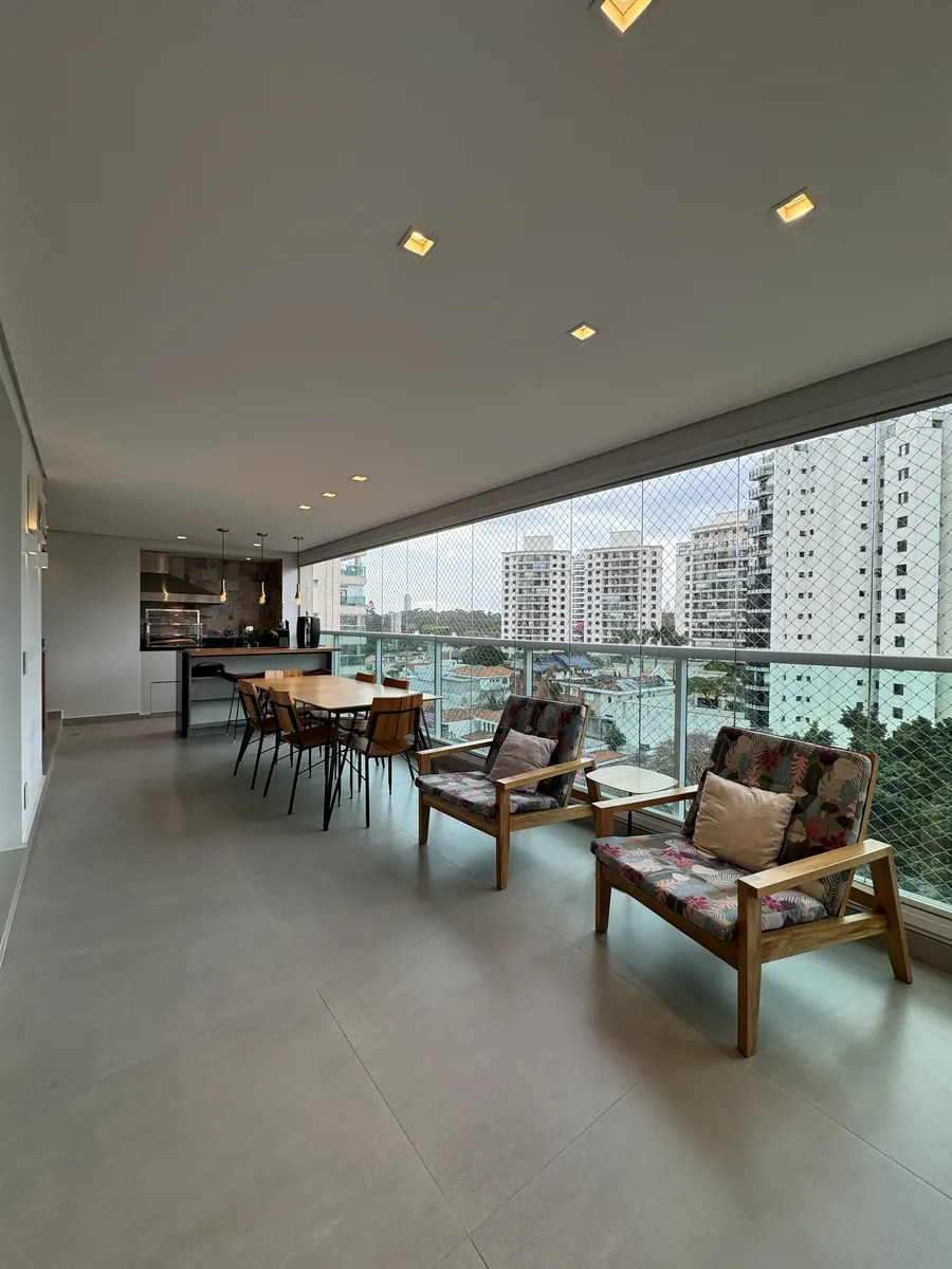 Varanda gourmet com poltronas e vista aberta — apartamento de 192 m² no Reserva Jardim Tarumã